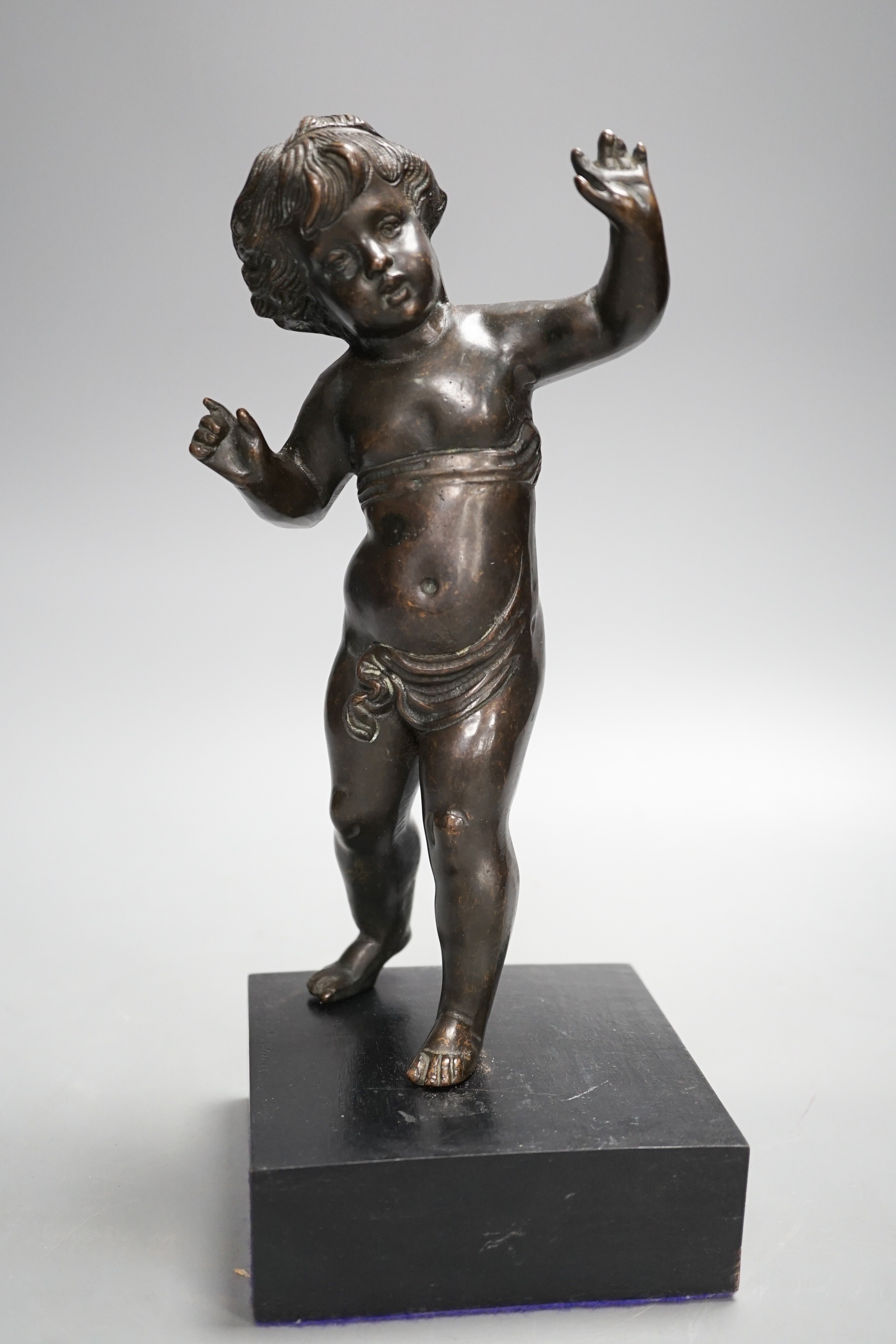 A 20th century bronze putto on wooden stand 29cm including stand